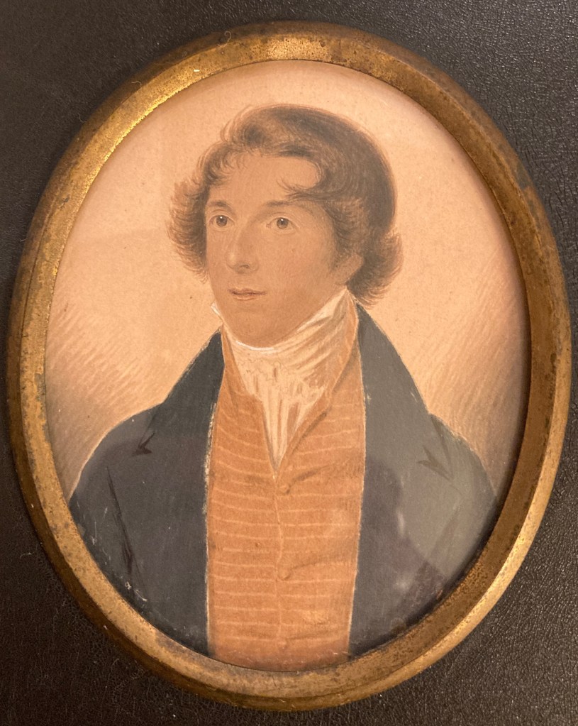 George Augustus Pollen with fasionably brushed hair, a high white neck cloth, yellow waistcoat and black coat.